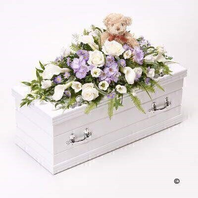 <h2>Blue Children's Casket Spray with Teddy Bear | Funeral Flowers</h2>
<ul>
<li>Approximate Size 70cm x 30cm</li>
<li>Hand created classic blue and lilac casket spray in fresh flowers</li>
<li>To give you the best we may occasionally need to make substitutes</li>
<li>Funeral Flowers will be delivered at least 2 hours before the funeral</li>
<li>For delivery area coverage see below</li>
</ul>
<br>
<h2>Liverpool Flower Delivery</h2>
<p>We have a wide selection of casket flowers offered for Liverpool Flower Delivery. Casket flowers can be provided for you in Liverpool, Merseyside and we can organize Funeral flower deliveries for you nationwide. Funeral Flowers can be delivered to the Funeral directors or a house address. They can not be delivered to the crematorium or the church.</p>
<br>
<h2>Flower Delivery Coverage</h2>
<p>Our shop delivers funeral flowers to the following Liverpool postcodes L1 L2 L3 L4 L5 L6 L7 L8 L11 L12 L13 L14 L15 L16 L17 L18 L19 L24 L25 L26 L27 L36 L70 If your order is for an area outside of these we can organise delivery for you through our network of florists. We will ask them to make as close as possible to the image but because of the difference in stock and sundry items it may not be exact.</p>
<br>
<h2>Liverpool Funeral Flowers | Casket Flowers</h2>
<p>This children's casket spray has been loving handcrafted by our expert florists. A sweet teddy bear is the focal point of this child’s floral casket arrangement. The fresh flower spray includes white calla lily and classic large-headed roses, lilac freesia, September flowers, purple lisianthus and is trimmed with seasonal foliages.</p>
<br>
<p>Funeral Casket Flowers the main tribute and are sometimes, depending on the family's wishes, the only flower arrangement. They are usually chosen by the immediate family.</p>
<br>
<p>Casket sprays are placed directly on top of the coffin. The sprays are large diamond shape tributes. The flowers are arranged in floral foam, which means the flowers have a water source meaning they look their very best for the day.</p>
<br>
<p>Containing 3 white roses, 5 white calla lilies, 4 lilac freesia, 3 purple lisianthus, 2 lilac September flower and seasonal mixed foliage together with a soft teddy bear who sits in the middle of the casket spray.</p>
<br>
<h2>Best Florist in Liverpool</h2>
<p>Trust Award-winning Liverpool Florist, Booker Flowers and Gifts, to deliver funeral flowers fitting for the occasion delivered in Liverpool, Merseyside and beyond. Our funeral flowers are handcrafted by our team of professional fully qualified who not only lovingly hand make our designs but hand-deliver them, ensuring all our customers are delighted with their flowers. Booker Flowers and Gifts your local Liverpool Flower shop.</p>
<br>
<p><em>Janice Crane - 5 Star Review on Google - Funeral Florist Liverpool</em></p>
<br>
<p><em>I recently had to order a floral tribute for my sister in laws funeral and the Booker Flowers team created a beautifully stunning arrangement. Thank you all so much, Janice Crane.</em></p>